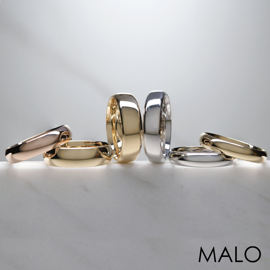 6 gold and white gold wedding bands arranged on a white background
