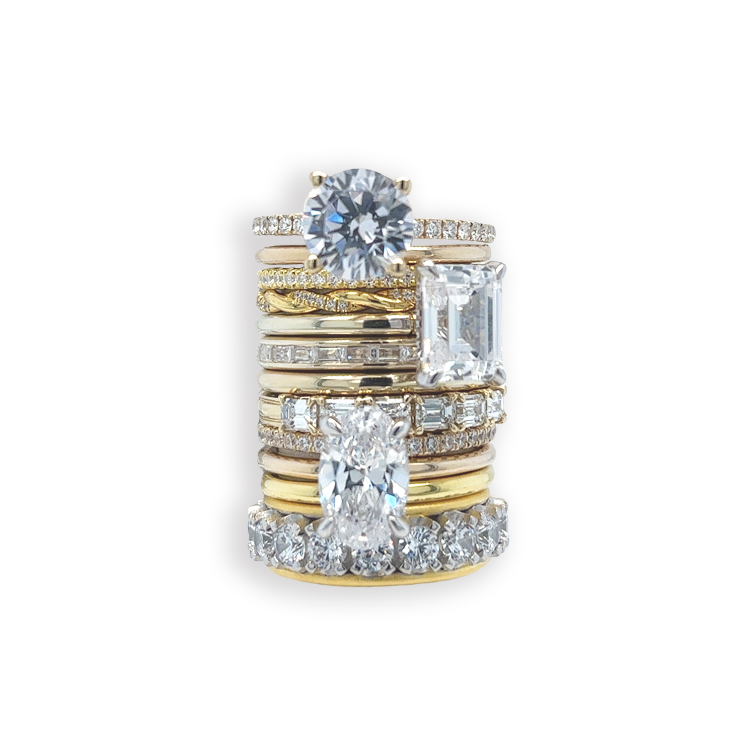 Stack of gold diamond engagement and wedding bands against a white background