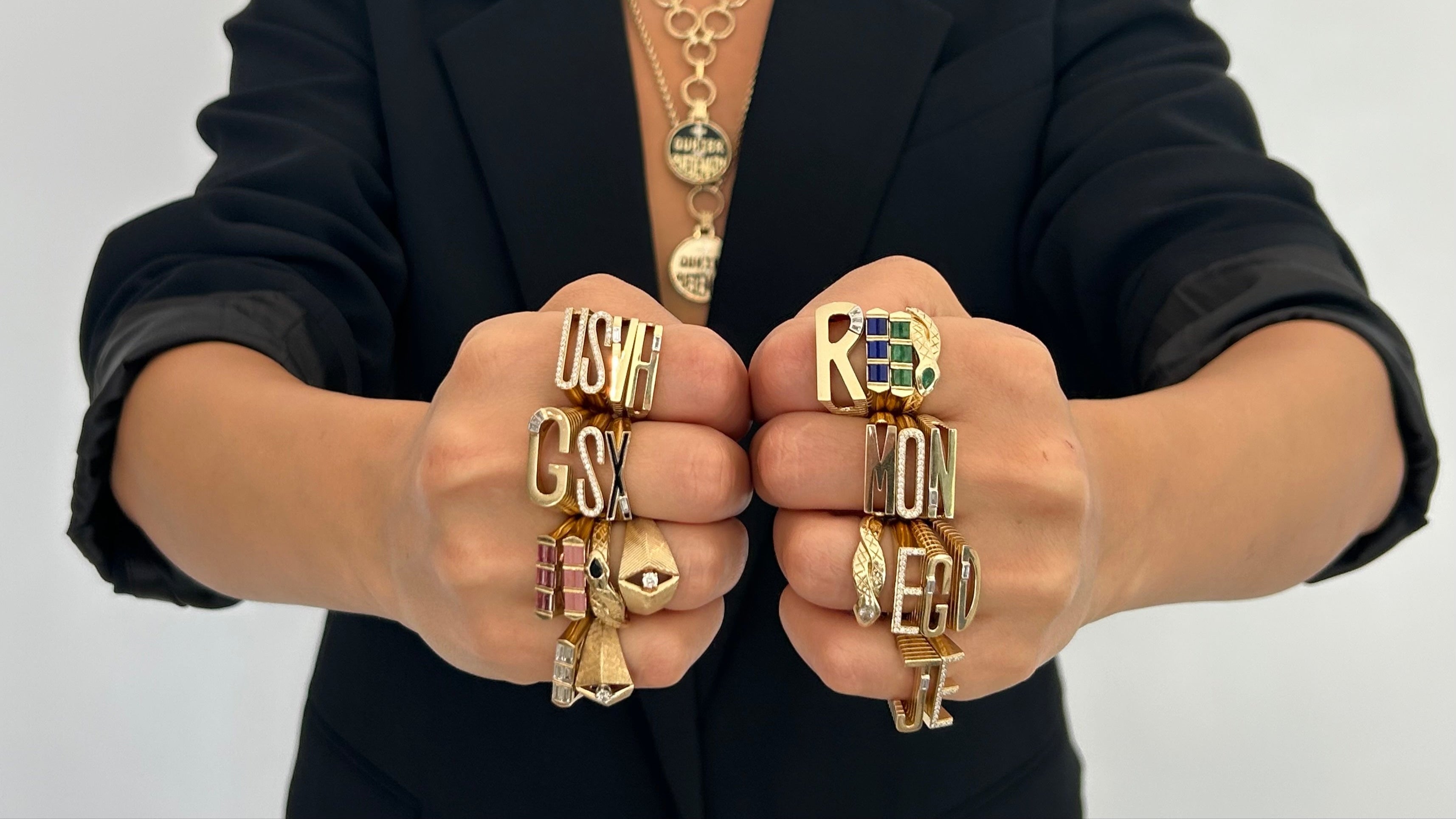 Woman with two fists touching as she dons Helena Rose rings on all fingers