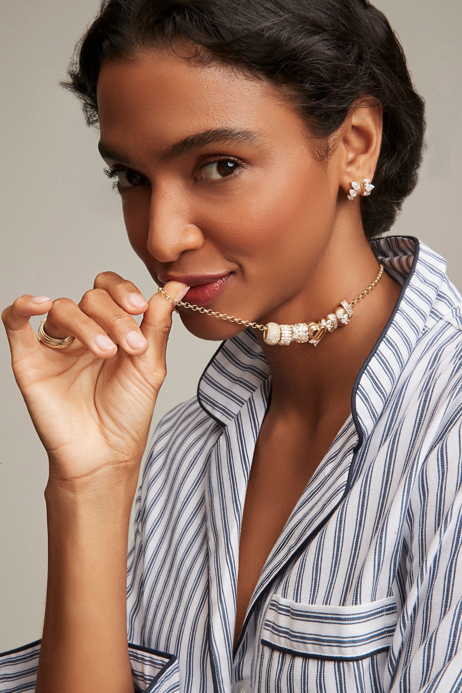 Woman holding up an Adina Reyter necklace she is wearing