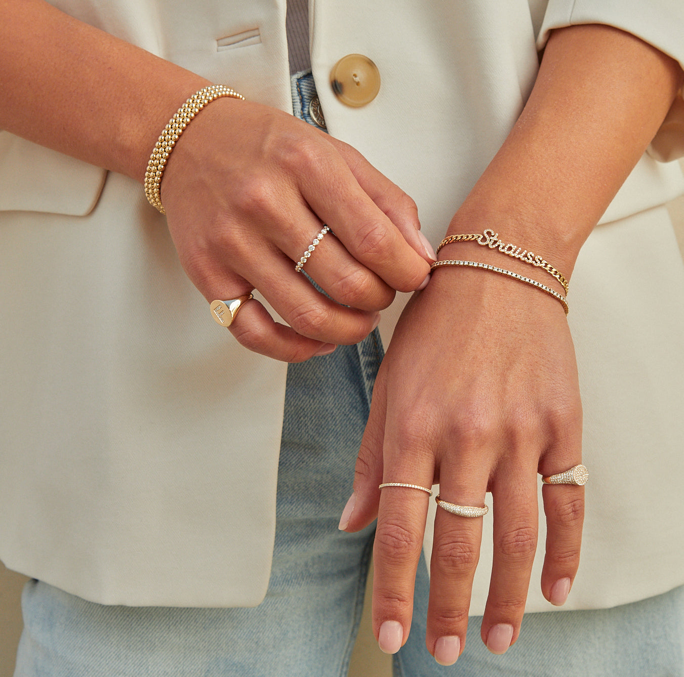 Features two hands adorned with EF jewelry, including rings and bracelets