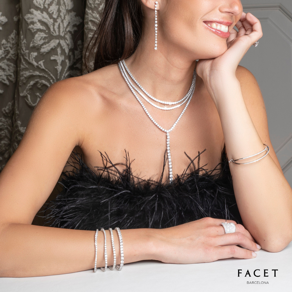 Woman shown from nose down, wearing Facet jewelry, including diamond necklaces and bracelets