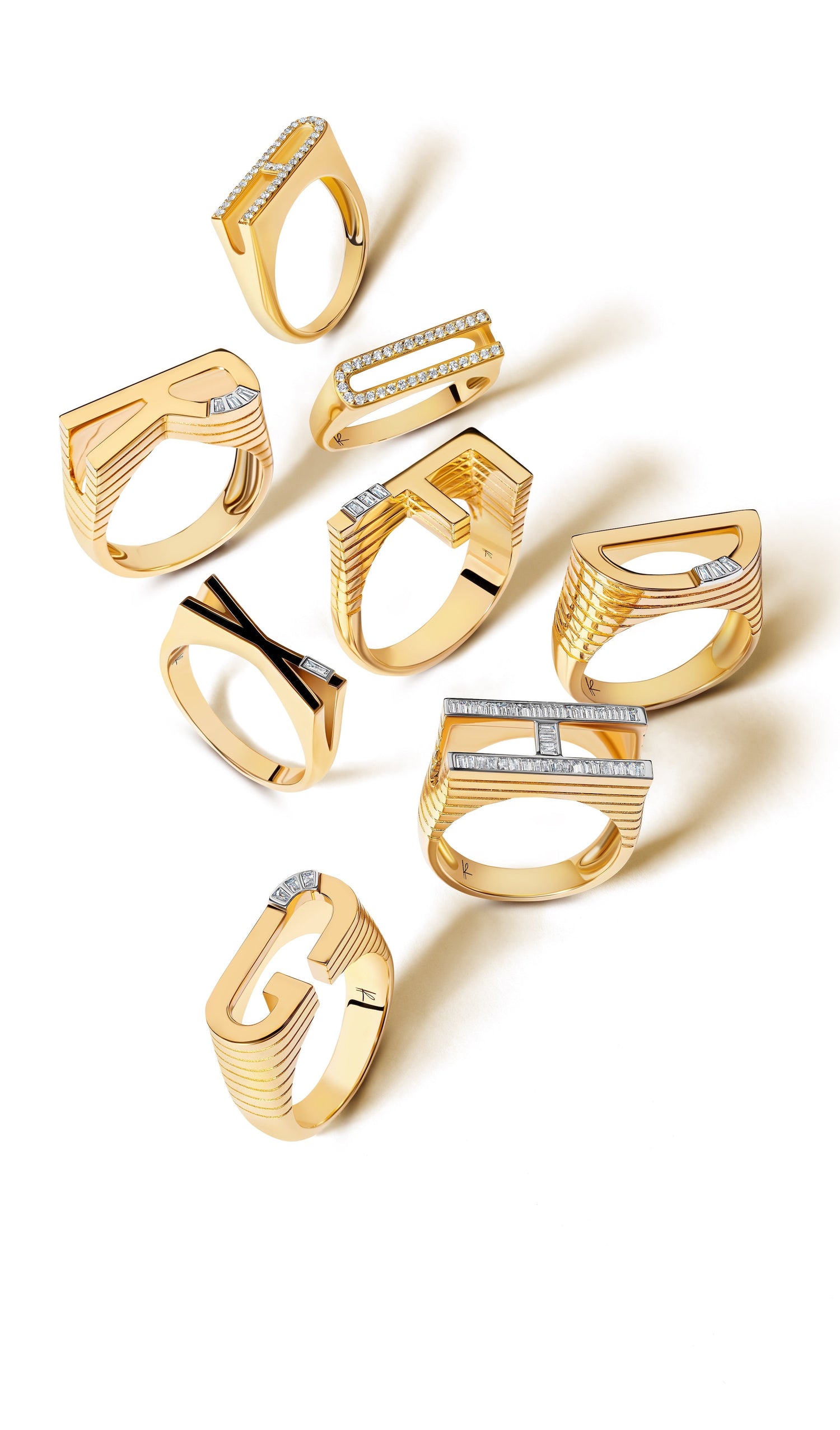 Gold initial rings set against a white background