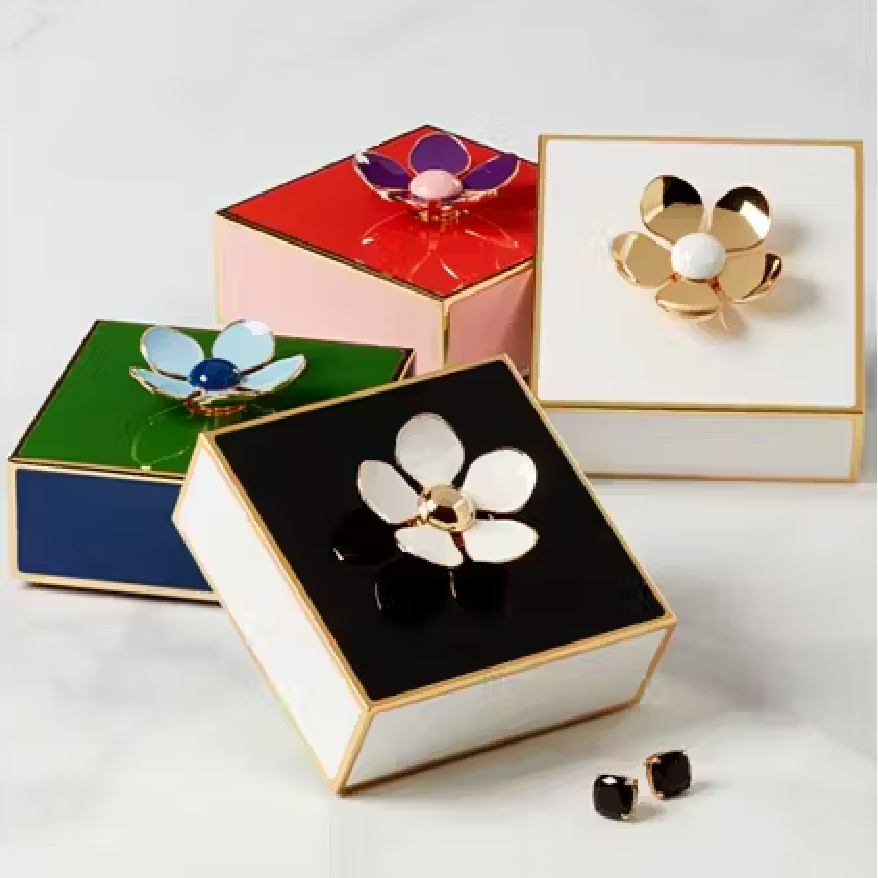 Image of four colorful Kate Spade jewelry boxes with flowers on top