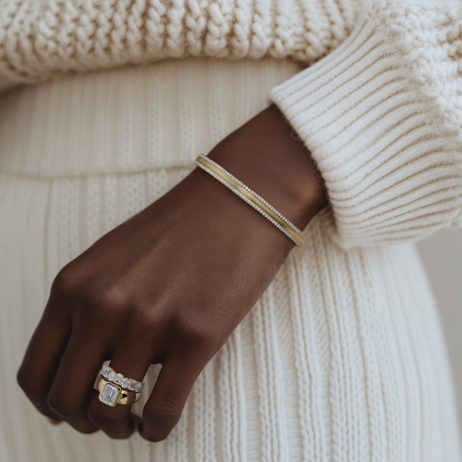 Woman's hand adorned with Noam Carver rings and a bracelet