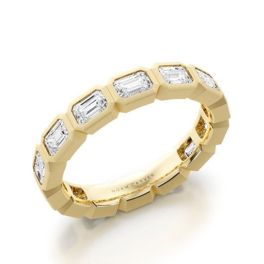 Yellow Gold Bezel Emerald cut diamond wedding band by Noam Carver against a white background