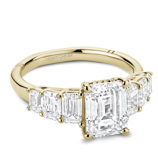 Noam Carver Yellow Gold Emerald Engagement Ring with Emerald Side Stones against a white background