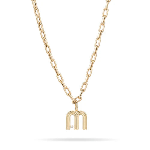 yellow gold chainlink necklace with a centerpiece charm shaped like an "m" against a white background