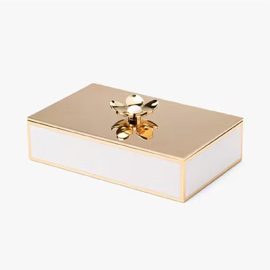 yellow gold metal box with a flower on the lid against a white background