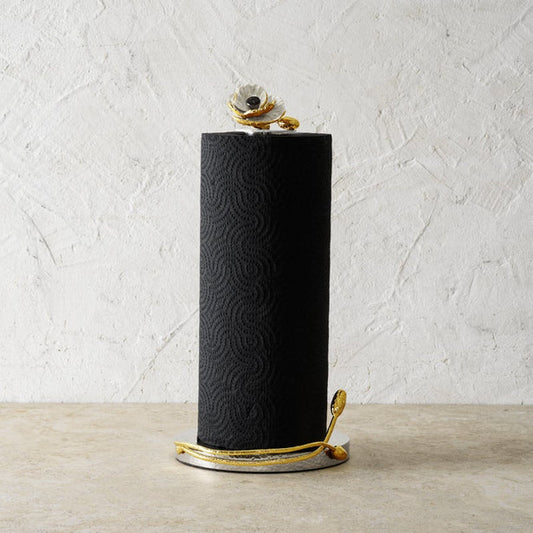 yellow gold Anemone Paper Towel Holder with black paper towels against a white stucco wall